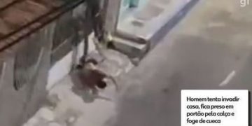 Homem tenta invadir casa, fica preso em portão pela calça e foge de cueca