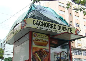 Homem improvisa barraca e dorme sobre quiosque de lanche