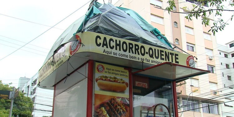 Homem improvisa barraca e dorme sobre quiosque de lanche
