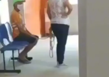 Um homem é levado amarrado para tomar vacina